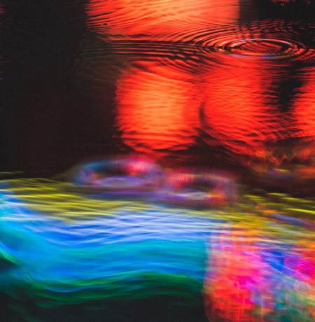Neon light reflections in puddle