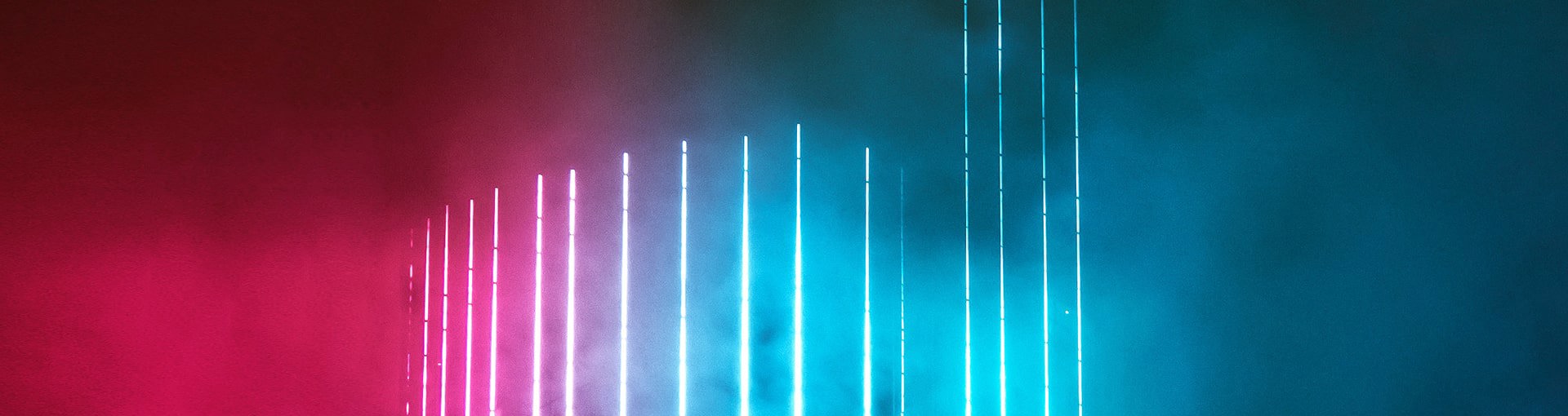 Modern high rise building with blue neon lights vertically along the building front