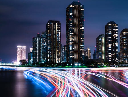 City at night with neon car trails 