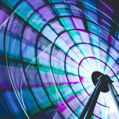Neon blue green and purple ferris wheel spinning