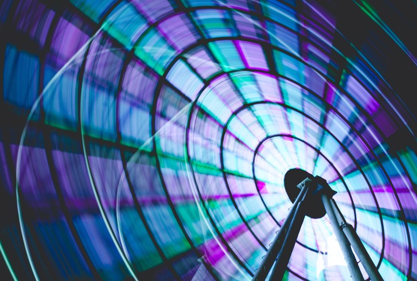 Neon blue green and purple ferris wheel spinning
