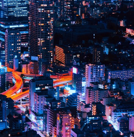 Nightime view of city with neon orange lighting up the roads