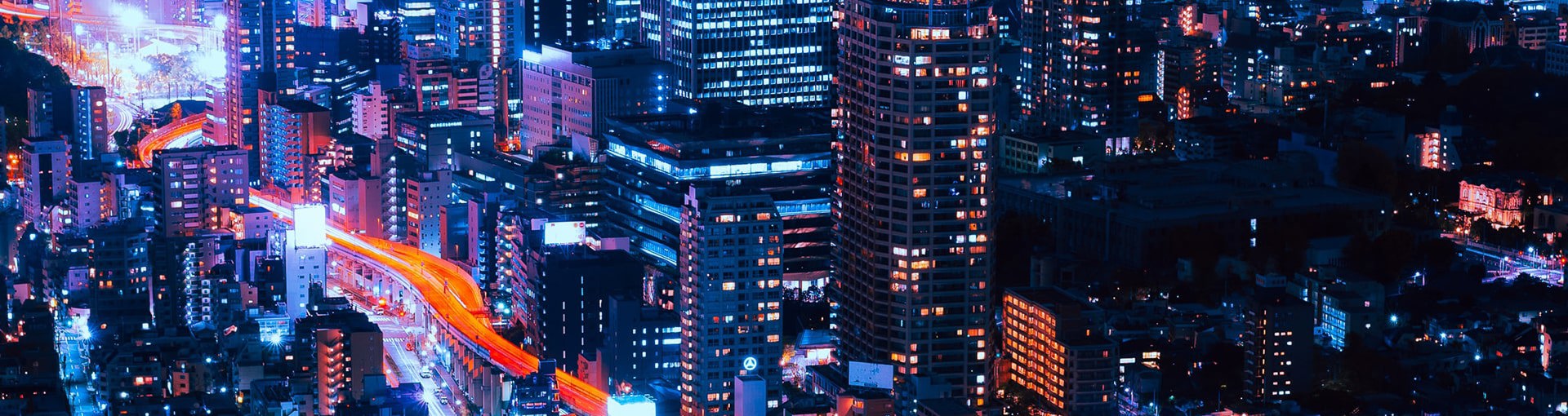 Nightime view of city with neon orange lighting up the roads